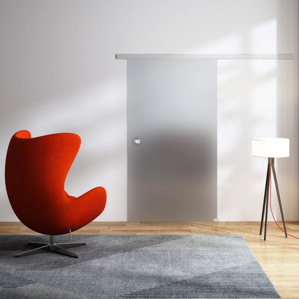 Einrichtungsszene mit einer Glasschiebetür, einem Sessel, einer Stehlampe und einem Teppich.