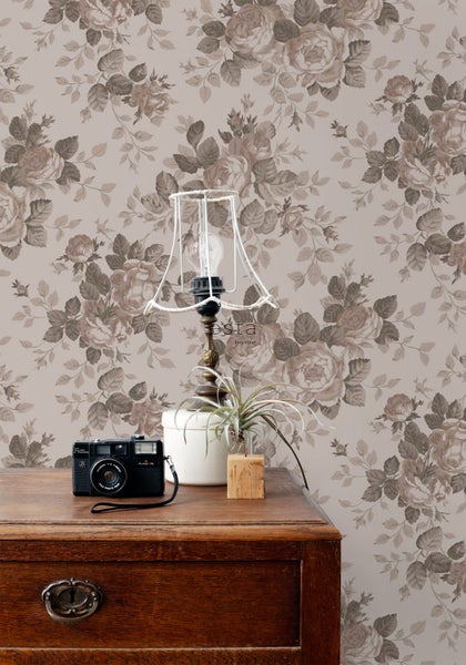 Wandgestaltung mit floralem Tapetenmuster, Tischleuchte und Dekoration auf Holzkommode