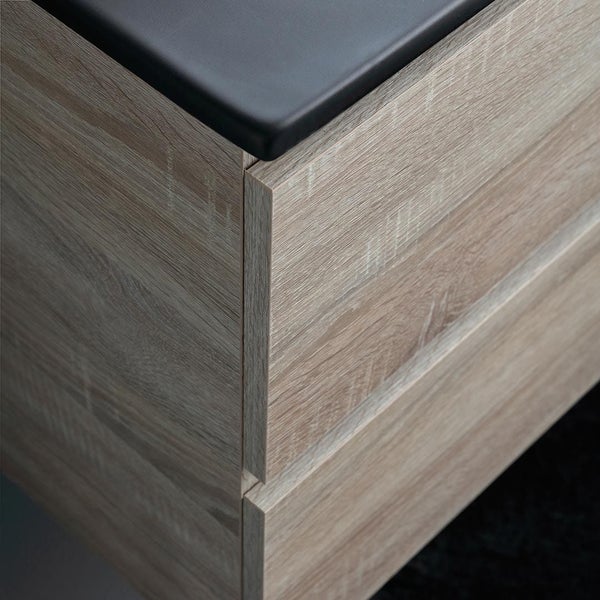 Detailaufnahme eines Badezimmermöbels in Holzoptik mit schwarzer Ablagefläche