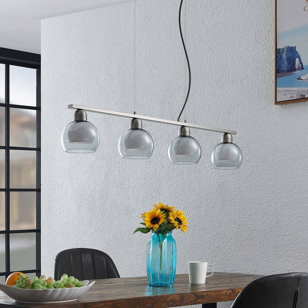 Esstisch mit Hängeleuchte mit vier grauen Glasschirmen.