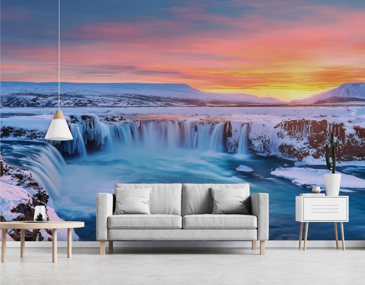 Wohnzimmer mit Fototapete eines Wasserfalls in winterlicher Landschaft, Sofa, Tisch und Kommode