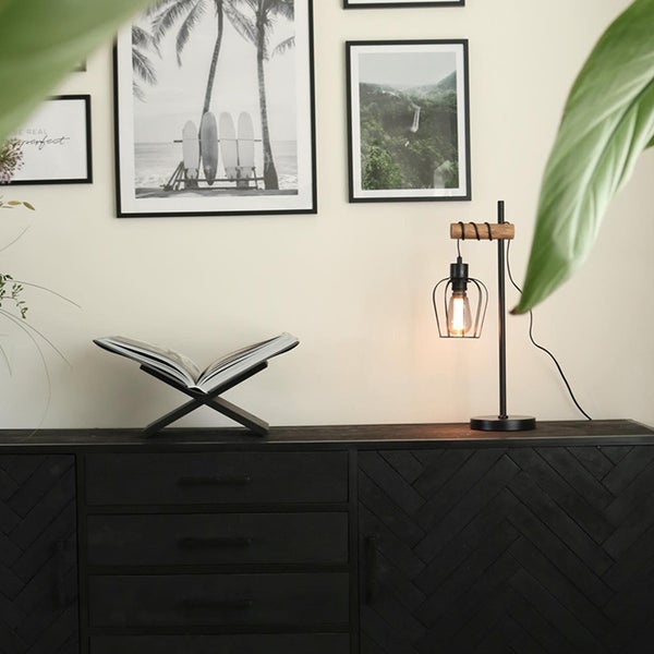 Dekoratives Wohnzimmer mit Kommode, Tischleuchte und Bildern an der Wand