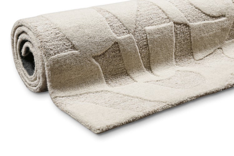 Teilweise aufgerollter Teppich mit strukturiertem 3D-Muster und weichem Flor.