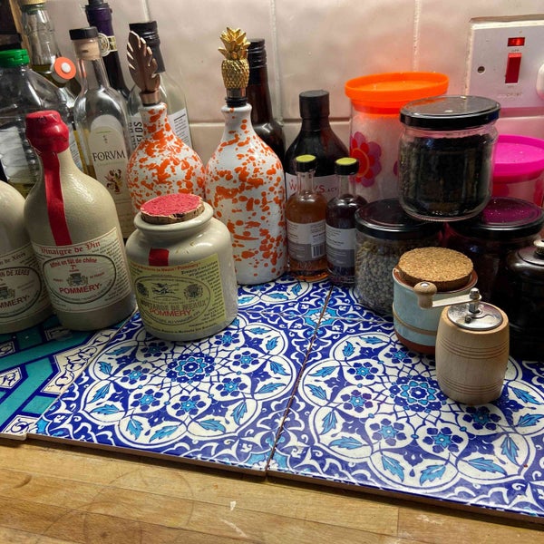 Küchenszene mit Fliesen, Flaschen und Vorratsgläsern