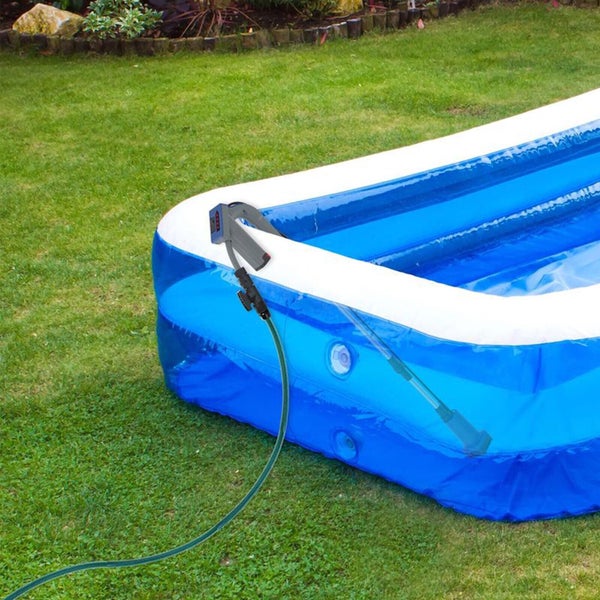 Ein aufblasbarer Pool auf einer Rasenfläche mit einem an einen Gartenschlauch angeschlossenen Poolreiniger zum Befüllen oder Säubern.