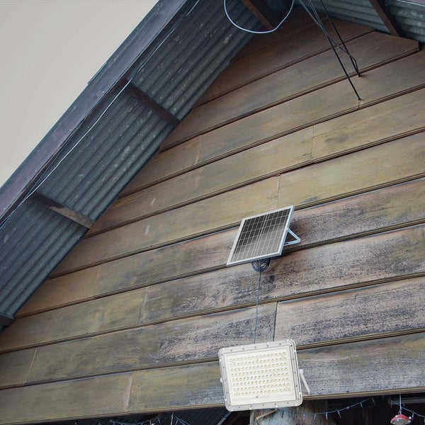 Solarpanel und LED-Strahler an einer Holzwand montiert