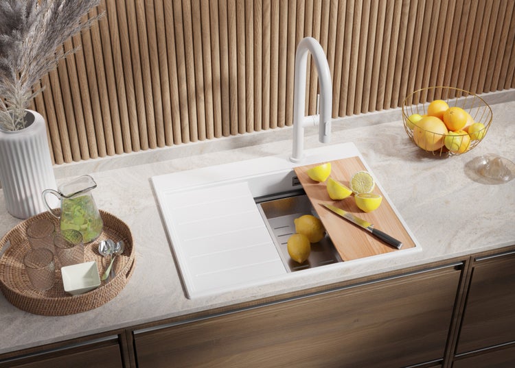 Spüle mit Schneidebrett, Wasserhahn und Obst auf einer Küchentheke