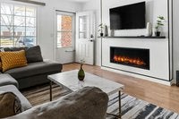 Wohnzimmer mit Sofa, Couchtisch, Fernseher und Kamin für eine gemütliche Atmosphäre.