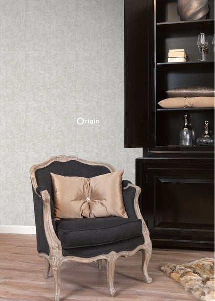 Elegantes Zimmer mit grauer Mustertapete, schwarzem Schrank und Sessel