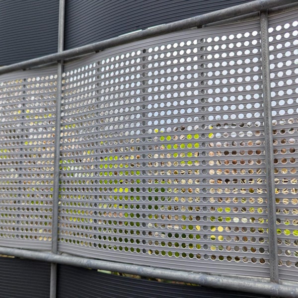 Detailansicht eines Schallschutzzauns mit Lochmuster und Metalleinfassung