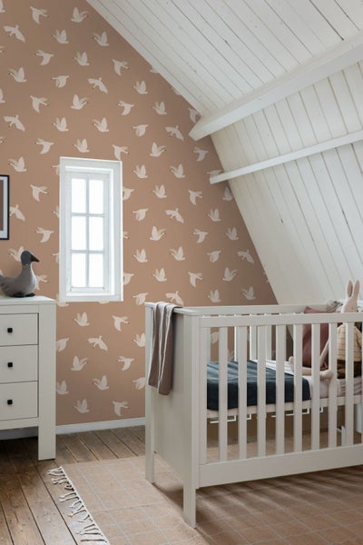Kinderzimmer mit Tapete mit Vogelmuster, Babybett und Kommode