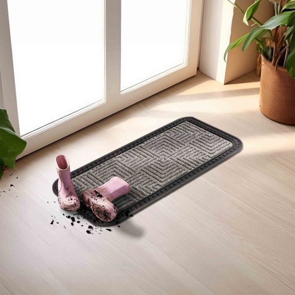 Schmutzfangmatte mit Gummistiefeln vor einer Tür