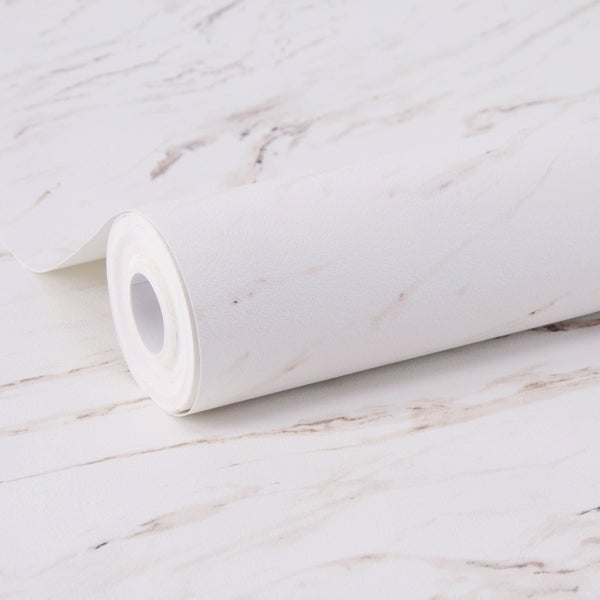 Dekoratives Stillleben mit Vase, Tasse und Dekoration auf einem Marmorständer vor einer Wand