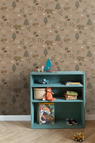 Kinderzimmer mit einer Tapete mit Tiermotiven und einem Regal mit Spielsachen und Büchern