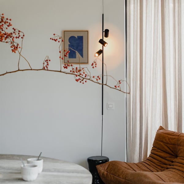 Moderne Inneneinrichtung mit Stehlampe, Sessel und Dekorationszweig