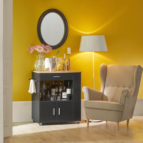 Barwagen mit Getränken, Gläsern, Blumen, Spiegel und Sessel in einem Zimmer