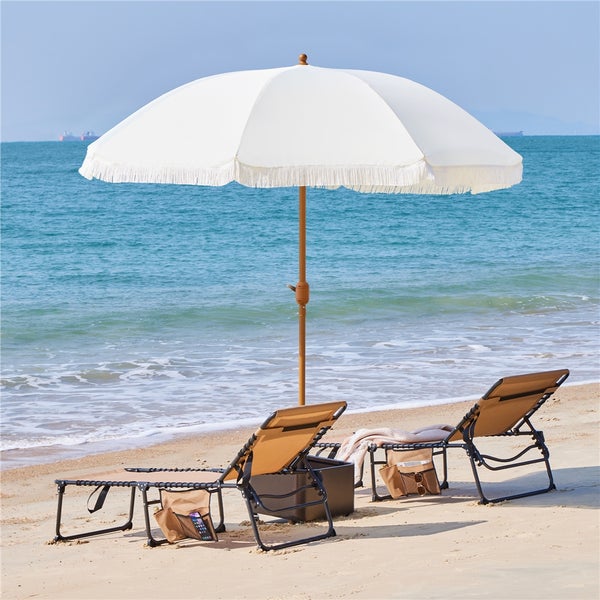 Strandszene mit zwei Liegestühlen und einem Sonnenschirm am Meer