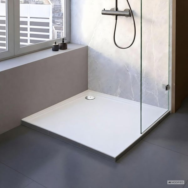 Moderne bodengleiche Duschwanne mit Glasduschwand und Armatur in einem hellen, gefliesten Badezimmer mit Fenster.