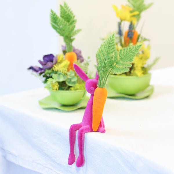 Dekoration mit rosa Hase und Karotte in frühlingshafter Szene