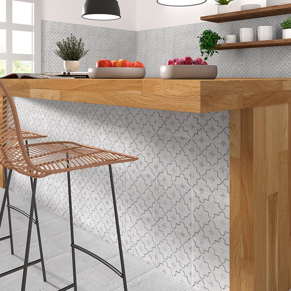 Moderne Küchentheke mit Holzarbeitsplatte und dekorativen Wandfliesen mit geometrischem Muster in einer hellen und wohnlichen Küche.