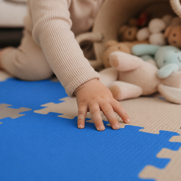 Kind spielt auf einer Puzzlematte aus Schaumstoff mit Spielzeugkorb und Plüschtieren auf dem Boden.