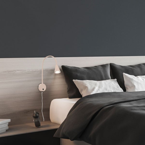 Schlafzimmer mit Bett, Nachttisch und Wandleuchte