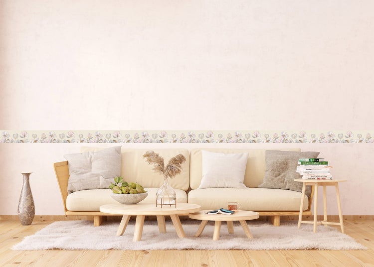 Modernes Wohnzimmer mit Holzsofa, beigen Polstern, zwei Couchtischen aus Holz und einer Tapetenbordüre mit Blumenmuster an der Wand.