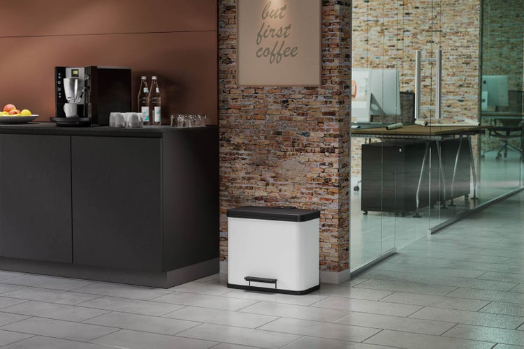 Szene eines Büros mit einer Küchenzeile, einer Glastür und einem weißen Treteimer