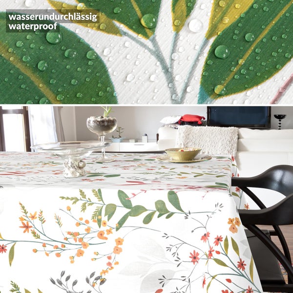 Wasserundurchlässige Tischdecke mit Blumen- und Blättermuster auf einem Esstisch, Detailaufnahme von Wassertropfen auf dem Stoff.