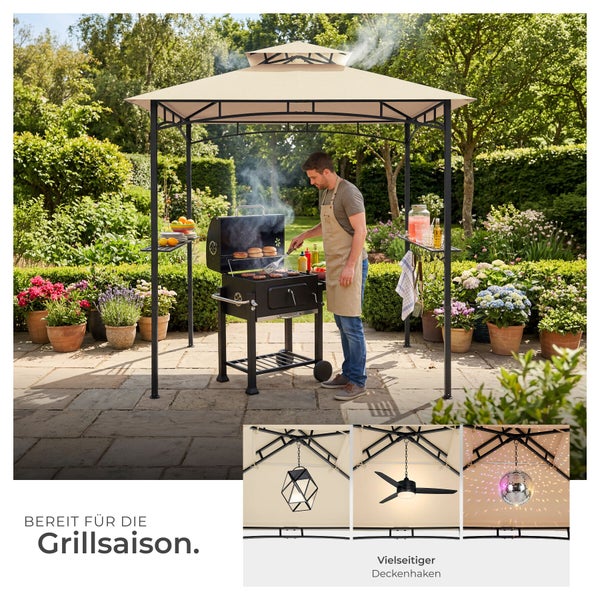 Grillpavillon mit beigem Dach und schwarzem Metallrahmen im Garten, ein Mann grillt darunter. Mit Ablagen und vielseitigem Deckenhaken für Zubehör.