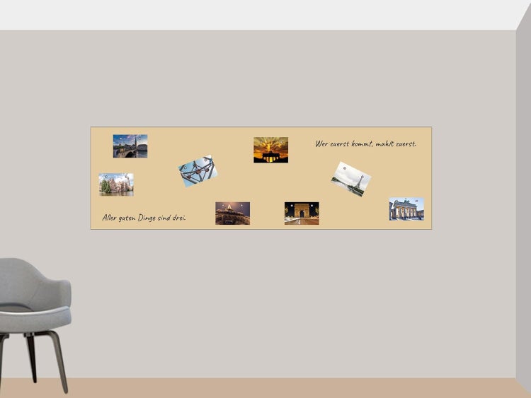 Beige Magnettafel mit Fotos von Sehenswürdigkeiten und Sprichwörtern an einer Wand neben einem grauen Stuhl in einem hellen Raum.
