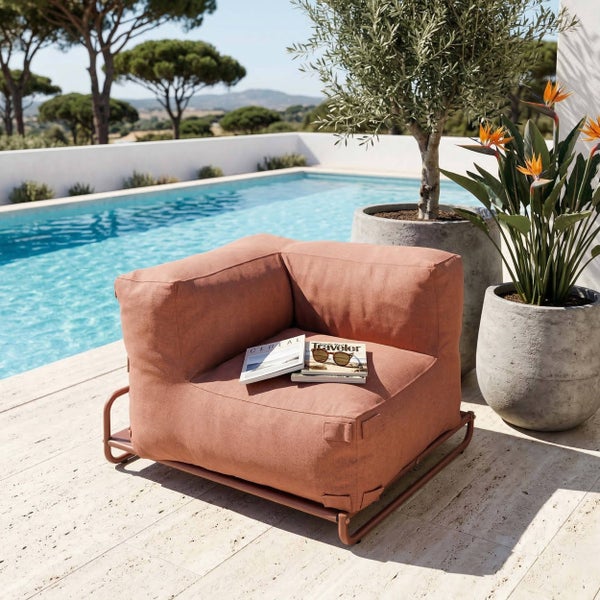 Moderner Outdoor-Ecksessel in Terrakotta auf einem Metallrahmen, platziert auf einer sonnigen Terrasse neben einem Pool.