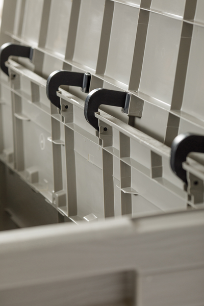 Efeu in gemustertem Übertopf auf Holzbeinen