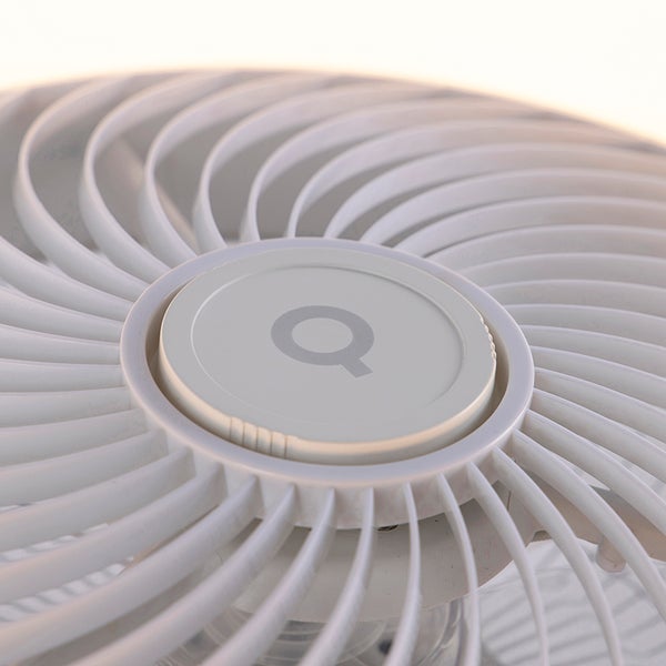 Nahaufnahme eines weißen Kunststoff-Ventilatorgitters mit Spiralmuster und einer zentralen Kappe mit dem Q Logo.