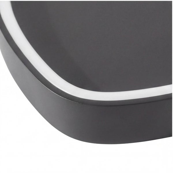 Nahaufnahme einer schwarzen LED-Leuchte mit abgerundeter Ecke und weißem Lichtrand.