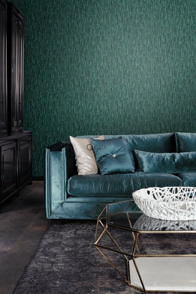 Wohnzimmer mit türkisfarbenem Sofa, Couchtisch und gemusterter Tapete