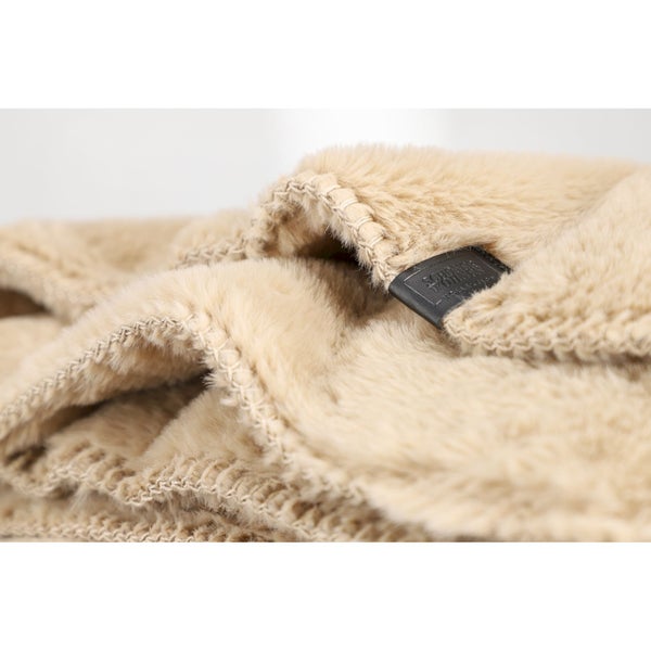 Detailaufnahme eines beigefarbenen Teddyfleece-Stoffs mit Markenschild