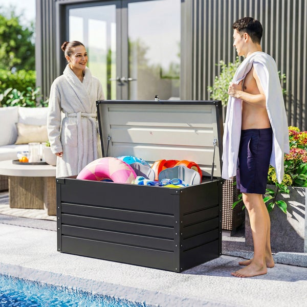Offene Metall-Gartenbox am Pool, gefüllt mit Schwimmspielzeug, in einer modernen Gartenanlage mit Personen.