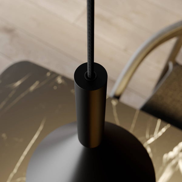 Nahaufnahme einer schwarzen Pendelleuchte mit Textilkabel über einem Tisch in Marmoroptik.