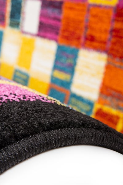 Nahaufnahme eines bunt gemusterten Teppichs mit geketteltem Rand und weichem Flor.
