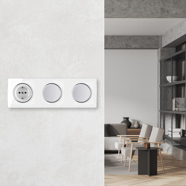 Dreifach Steckdosenrahmen mit Schuko Steckdose und zwei Lichtschaltern vor einem modernen Wohnraum mit Sesseln.