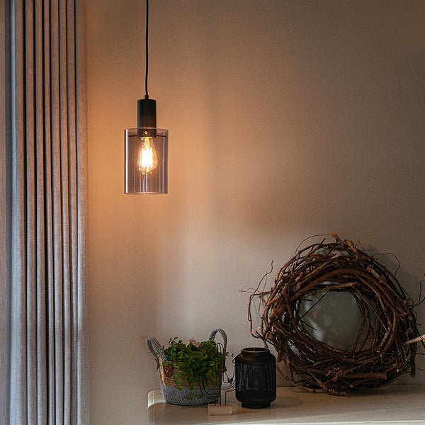 Innenaufnahme mit Pendelleuchte, Dekorationen wie ein Kranz aus Zweigen, eine Laterne und eine Topfpflanze