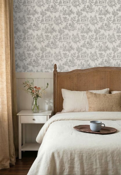 Schlafzimmer mit Toile-de-Jouy-Tapete, weißer Holzvertäfelung, Holzbett mit Kopfteil aus Wiener Geflecht und weißem Nachttisch.
