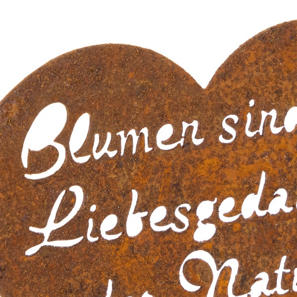 Edelrost-Herz mit dem ausgeschnittenen Schriftzug Blumen sind Liebesgedanken der Natur.