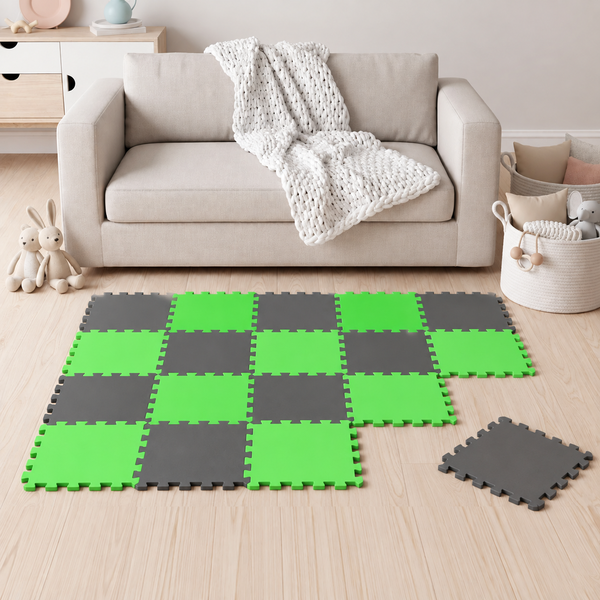 Spielteppich aus ineinandergreifenden Schaumstoffmatten im Schachbrettmuster in einem Wohnzimmer mit Sofa und Spielzeug.