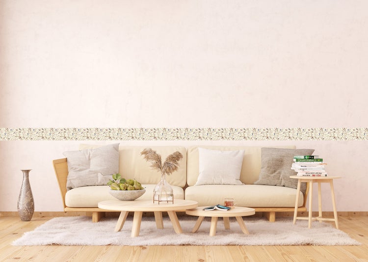 Hell eingerichtetes Wohnzimmer mit Tapetenbordüre mit Naturmotiv, modernem Sessel, Beistelltisch und gestreiftem Teppich.
