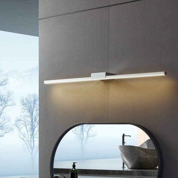 Moderne LED Spiegelleuchte in einem minimalistischen Badezimmer über einem runden Spiegel mit Reflexion von Waschbecken und Armatur.