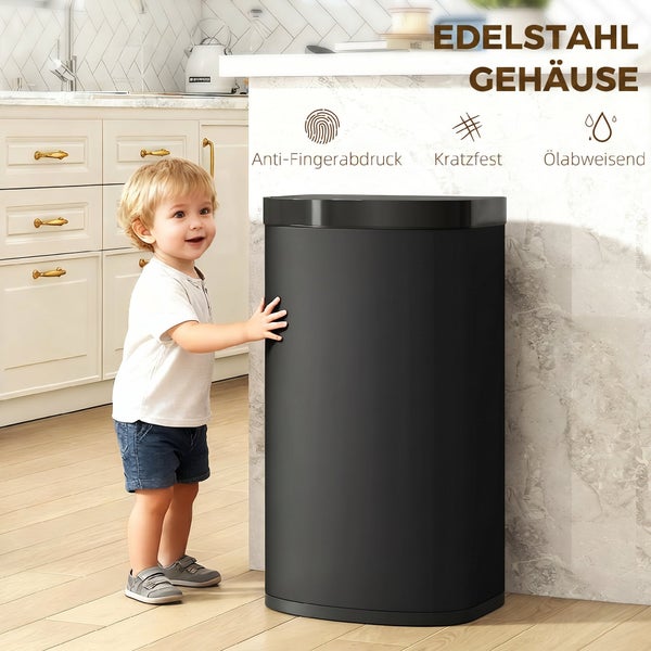 Ein Kleinkind steht neben einem ovalen Abfalleimer aus Edelstahl mit Anti-Fingerabdruck, kratzfester und ölabweisender Oberfläche in einer Küche.