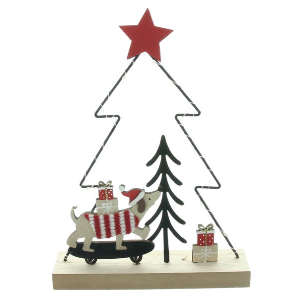 Weihnachtsdekoration aus Holz und Metall in Form eines Tannenbaums mit Hund auf einem Skateboard und Geschenken auf einem Holzsockel.