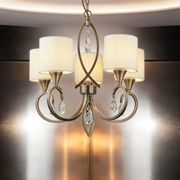 Deckenleuchte mit fünf Lampenschirmen und dekorativen Kristallen.